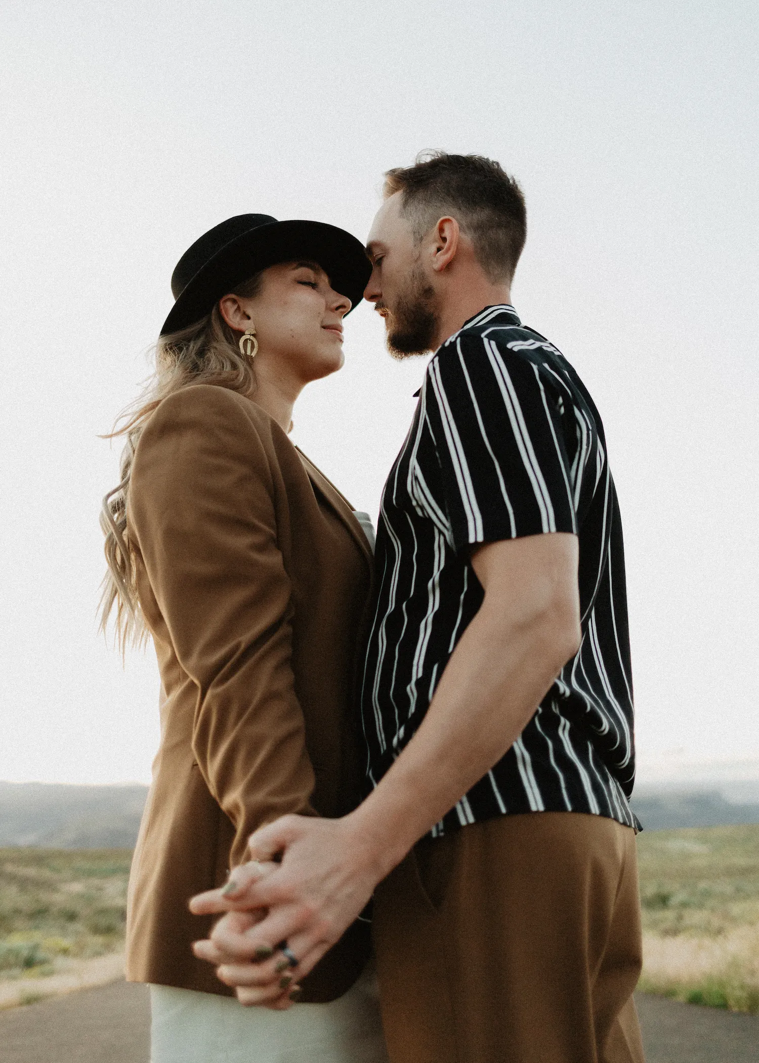 Couples portrait holding hands beneath an open sky